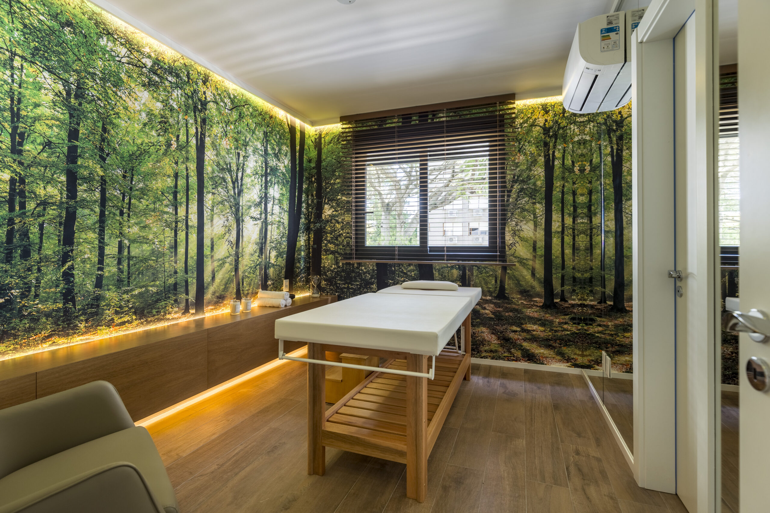 sala de massagem com uma maca no meio, e papel de parede de bamboo